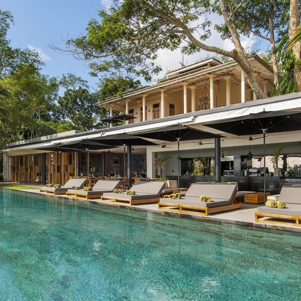 Infinity pool and loungers in front of an open colonial-style villa at Haritha Villas + Spa in Hikkaduwa, Sri Lanka