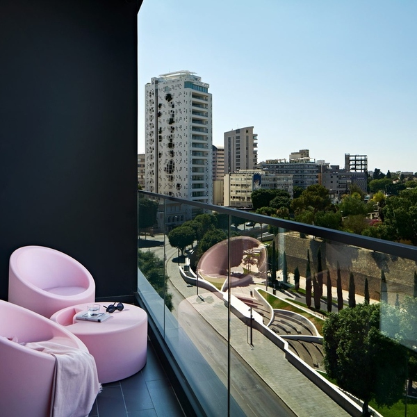 Balcony with pink lounge chairs overlooking the city at MAP Boutique Hotel in Nicosia, Cyprus
